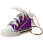 A miniature purple canvas high-top sneaker keychain with white laces tied in a bow, a white rubber toe cap and sole, and a gold-tone metal key ring on a white background.