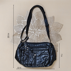 Black handbag with measurements on a textured beige background