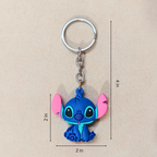 Blue cartoon character keychain with pink accents on a beige background
