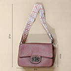 Pink shoulder bag with a patterned strap on a beige background, showing measurements.