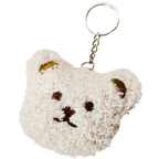 A small plush bear-face keychain . The keychain is cream-colored with embroidered brown facial features and gold-toned ear accents, attached to a silver metal ring and chain on a white background.