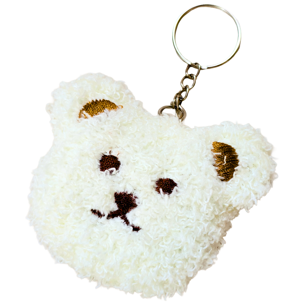 A white fluffy teddy bear head keychain with embroidered brown eyes, nose, and ears, attached to a gold metal key ring on a plain white background.