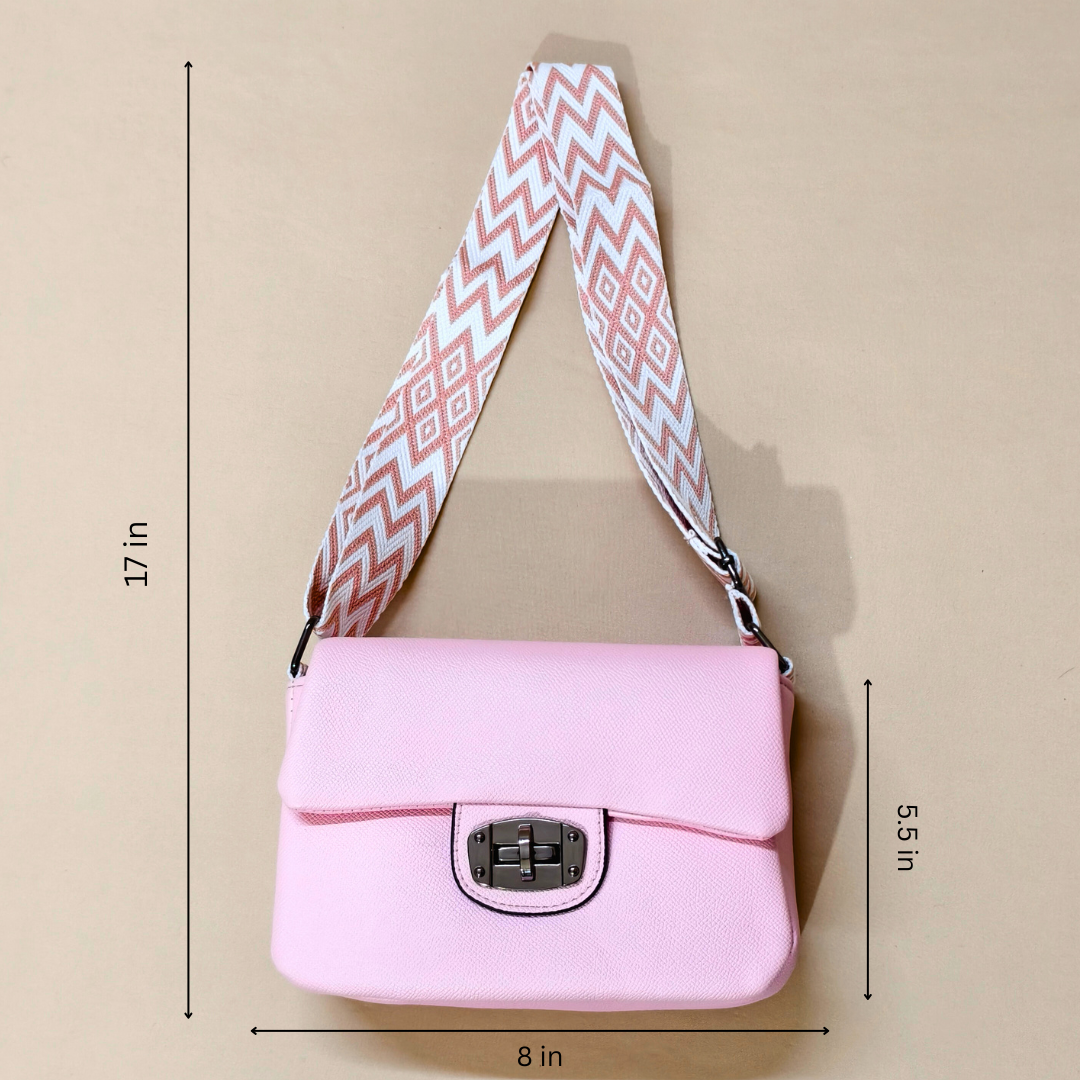 Pink shoulder bag with a patterned strap on a beige background, showing measurements.