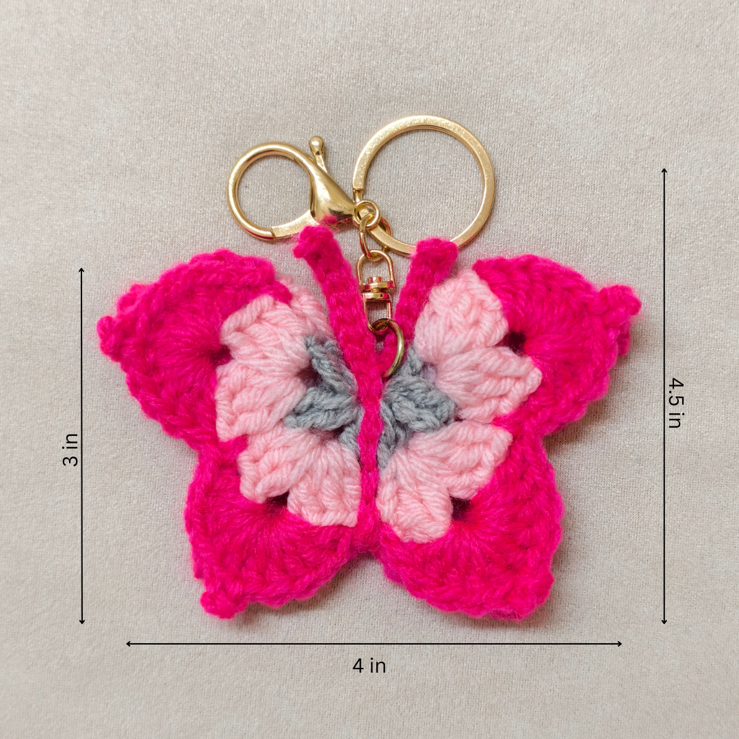 Crocheted butterfly keychain with gold ring and measurements on a beige background