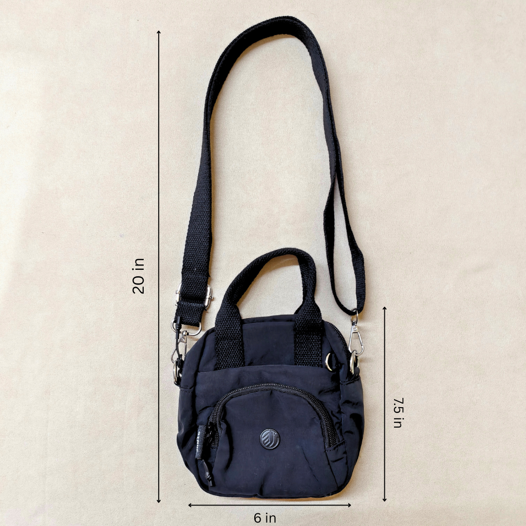 Black crossbody bag with measurements on a beige background