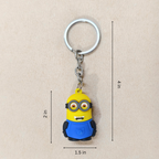 Minion keychain with measurements on a beige background