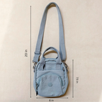 Light blue crossbody bag with measurements on a beige background