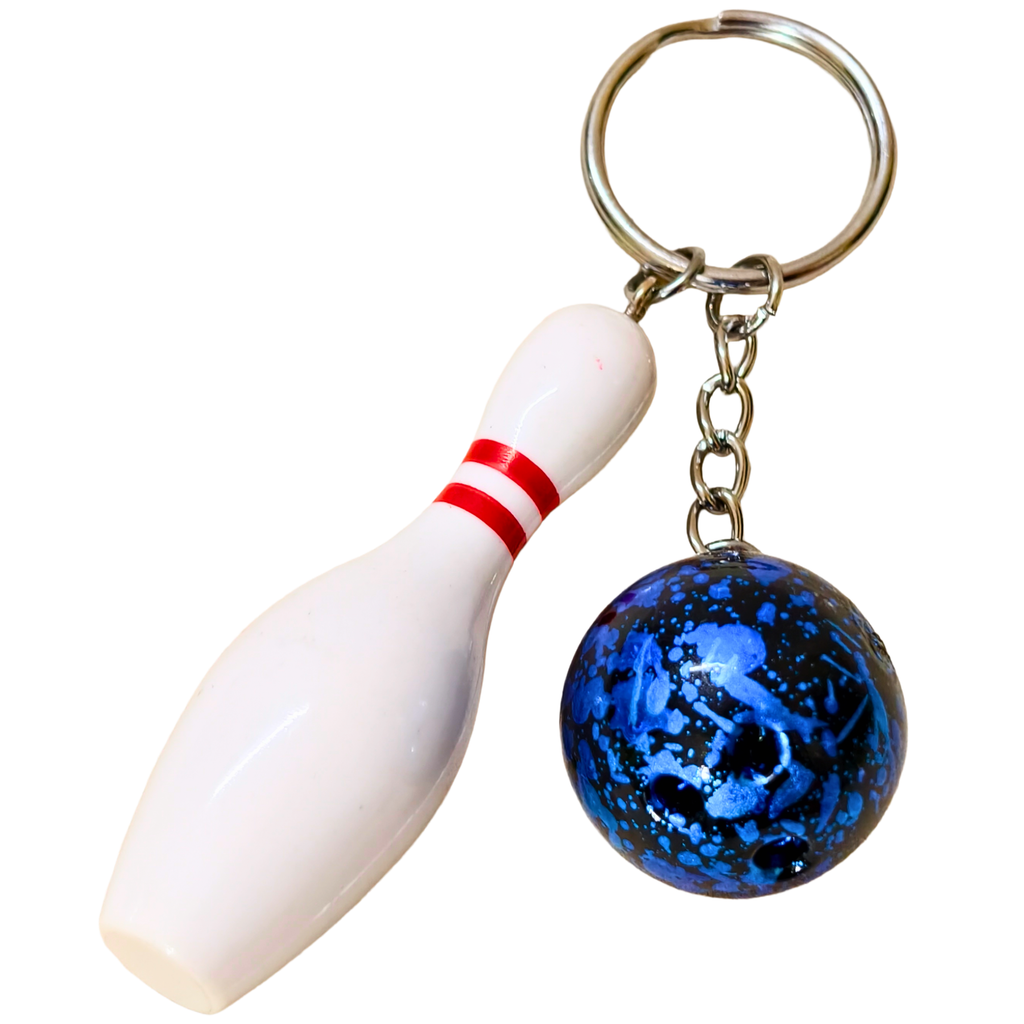 A bowling-themed keychain featuring a white bowling pin charm with red stripes and a blue marbled glass bowling ball hanging from a silver metal split ring and chain, shown against a plain white background.