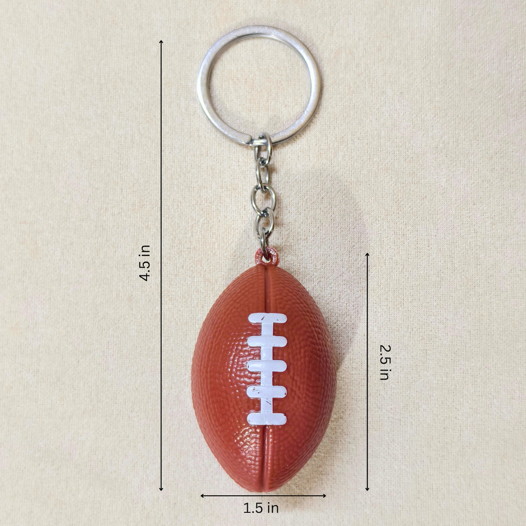 A football-shaped keychain with a silver metal key ring and chain, shown on a beige background with black dimension lines and text indicating measurements of 4.5 inches in height, 1.