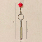 silver metal Cricket Bat and Ball  keychain with a small Cricket Ball attached, showing measurements against a plain beige background.


