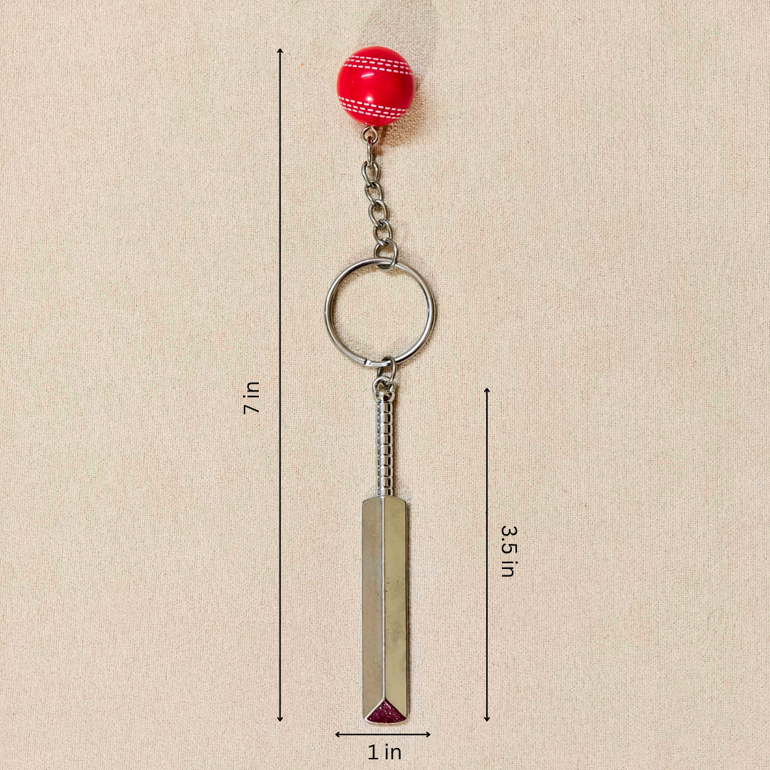 silver metal Cricket Bat and Ball  keychain with a small Cricket Ball attached, showing measurements against a plain beige background.


