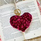 Heart-shaped keychain with gold ring on an open book
