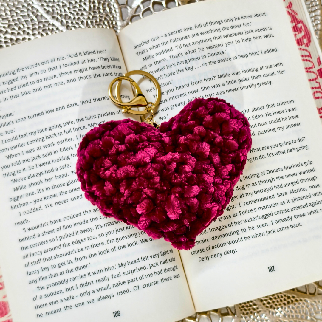 Heart-shaped keychain with gold ring on an open book