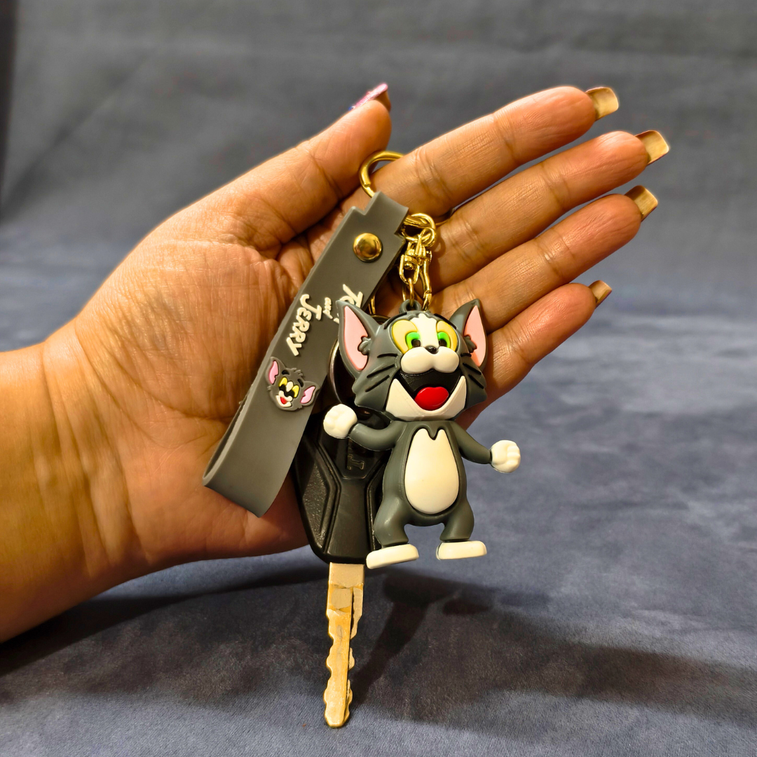 Keychain with cartoon character held by a hand against a gray background
