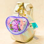 Heart-shaped keychain with a unicorn design on a beige background
