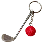 A novelty golf keychain featuring a silver metal golf club head and chain with a small red textured golf ball charm, isolated on a white background.
