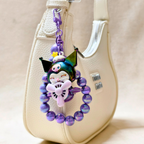 Colorful keychain with a character design attached to a beige bag.