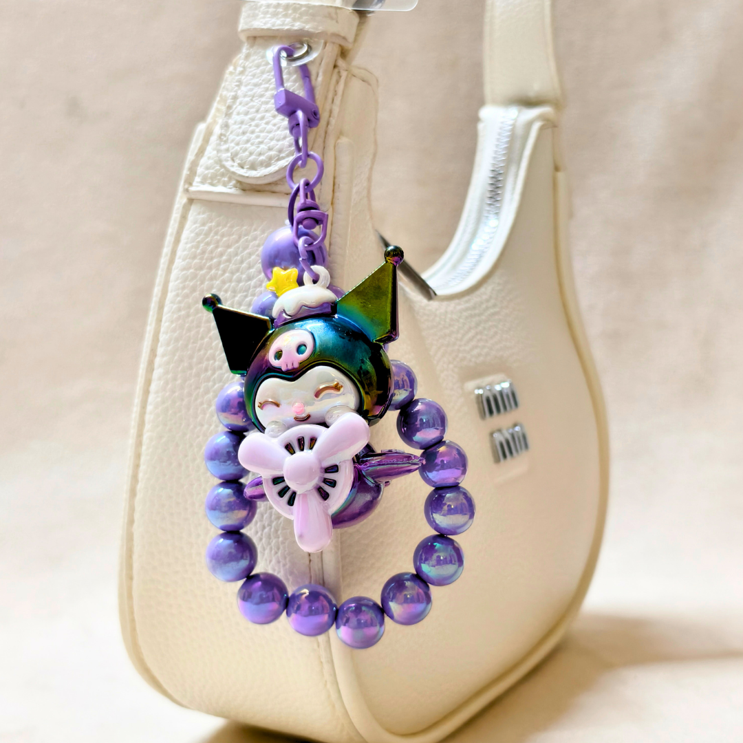Colorful keychain with a character design attached to a beige bag.