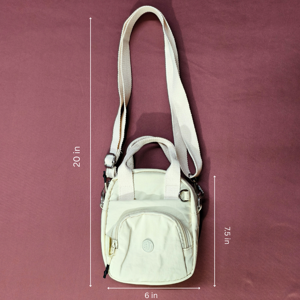 Beige crossbody bag with measurements on a maroon background