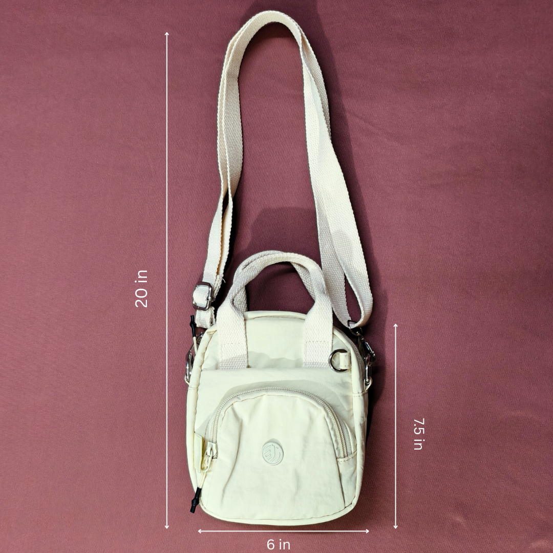 Beige crossbody bag with measurements on a maroon background