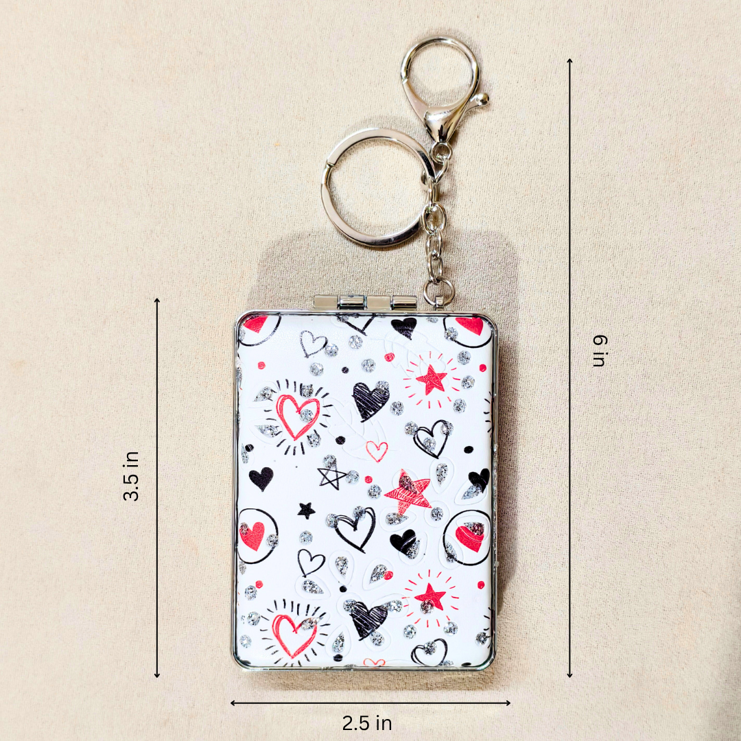 A small rectangular keychain wallet with a white background and a heart-and-star pattern, shown with metal key rings and chain. Black and red heart illustrations, plus measurement lines and labels indicating 3.