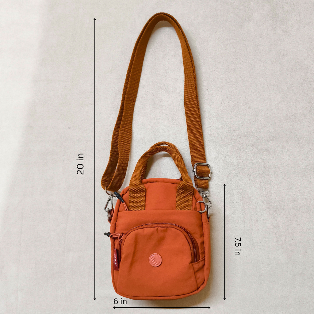 Orange crossbody bag with measurements on a light gray background