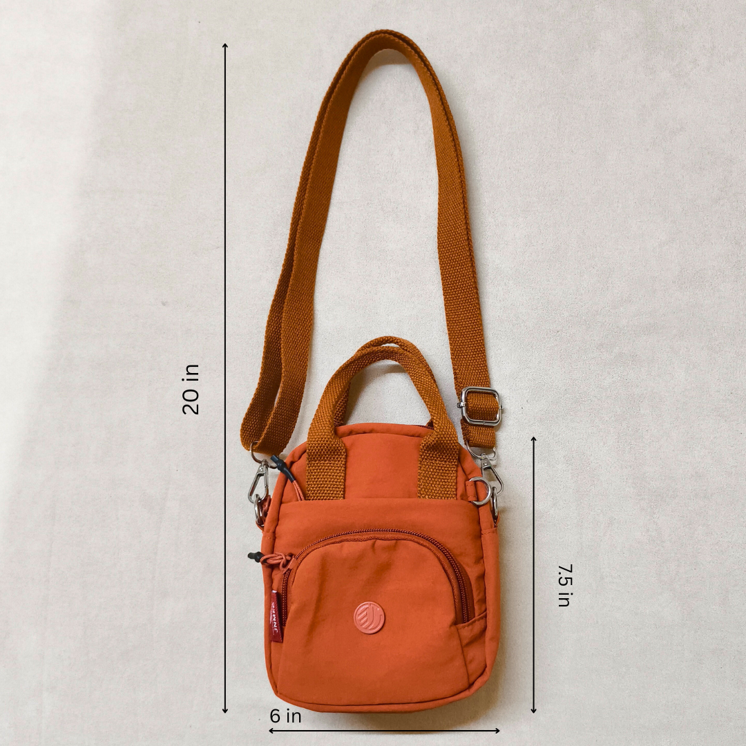 Orange crossbody bag with measurements on a light gray background