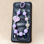 Phone case with a decorative bead chain on a beige background