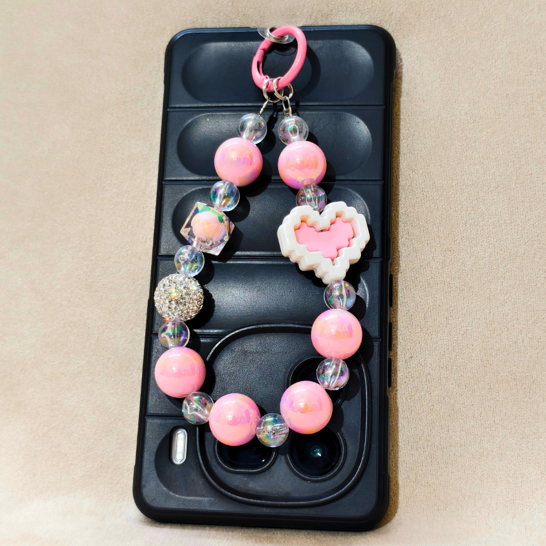 Phone case with a decorative bead chain and heart charm on a beige background