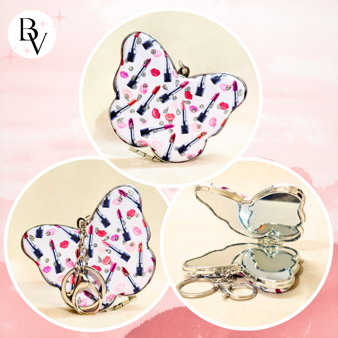 A butterfly-shaped compact mirror keychain shown in three views: closed with a lipstick-patterned wing and keychain ring, closed with the wing folded, and open showing a butterfly-shaped mirror. The wing pattern features lipstick tubes and red lips on a white background.