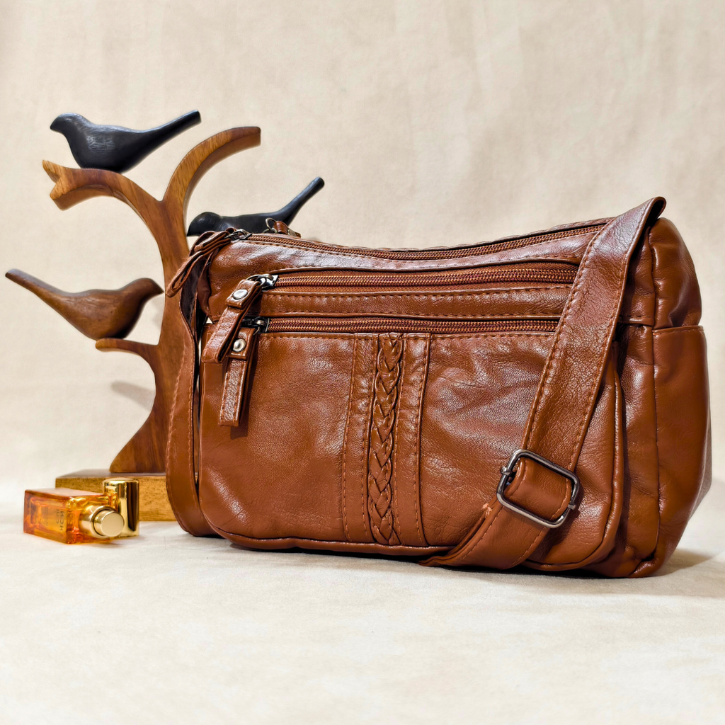 Brown leather handbag with decorative braiding on a beige background
