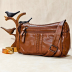 Brown leather handbag with decorative braiding on a beige background