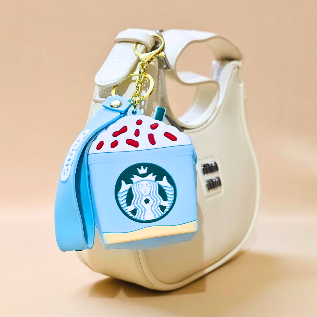 Starbucks-themed air pod case with a keychain on a beige background