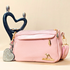 Pink handbag with a heart-shaped keychain on a beige background