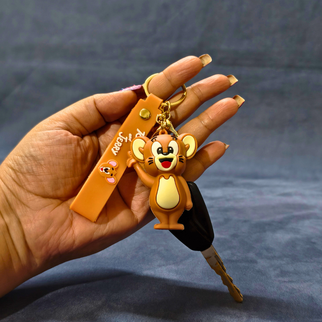 Hand holding a keychain with a cartoon monkey design against a dark background