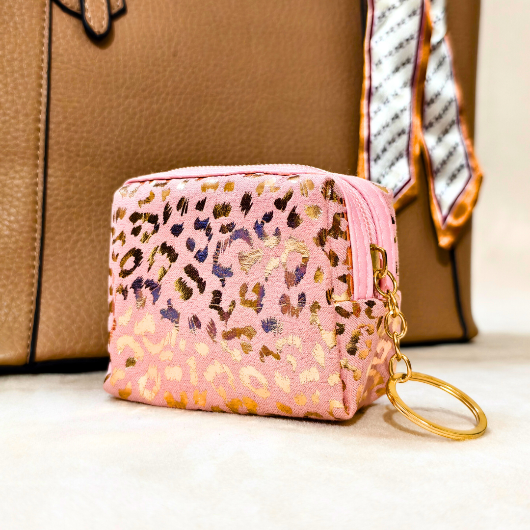Pink leopard print coin purse with gold keychain on a neutral background