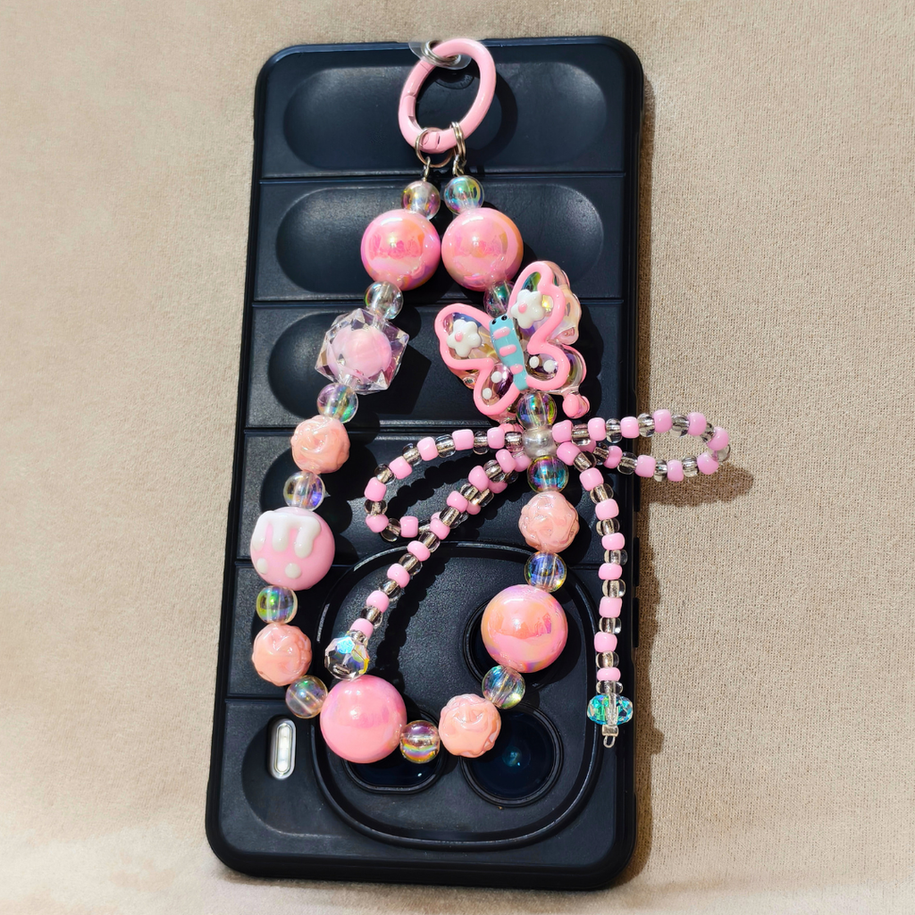 Phone case with a decorative pink butterfly charm on a beige background