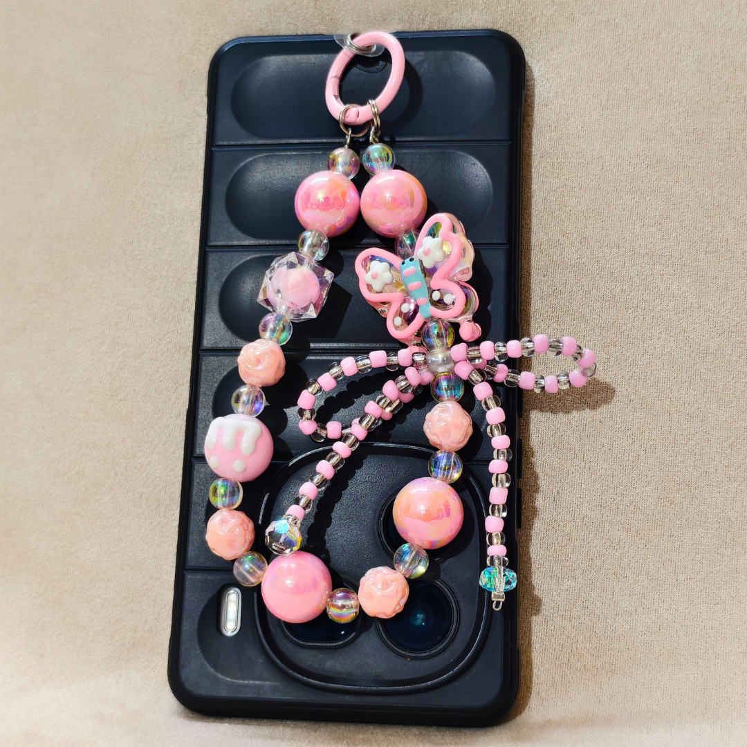 Phone case with a decorative pink butterfly charm on a beige background