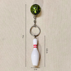 A novelty bowling keychain showing measurements, featuring a green and black mottled bowling ball and a white bowling pin with a red stripe, attached to a silver split ring.

Details