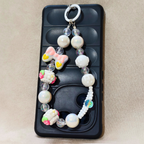 Decorative phone case with beads and a bow on a beige background