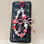 Phone case with colorful beaded charm featuring a character on a beige background