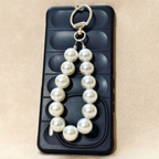 Pearl keychain on a black ice cube tray with a beige background