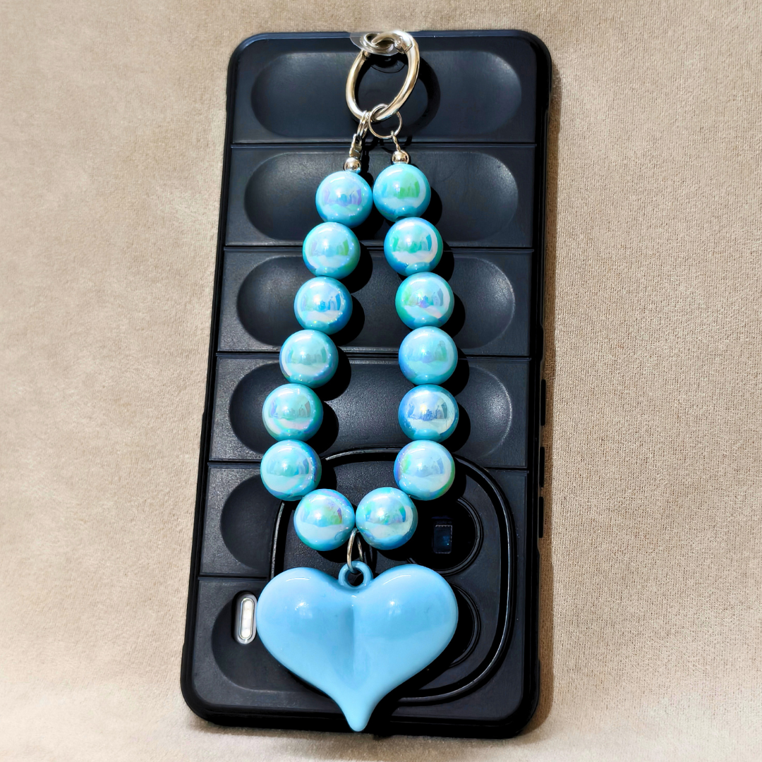 Blue beaded keychain with a heart pendant on a black phone case.
