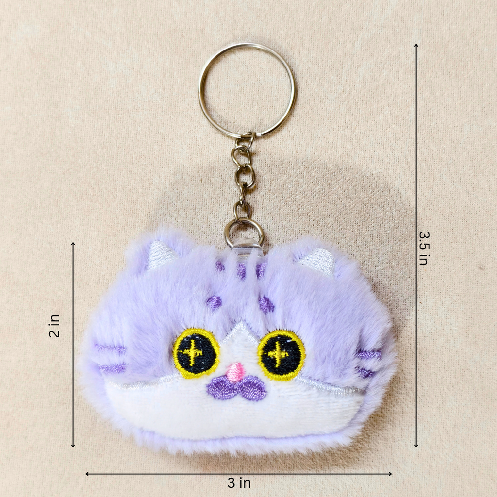 A plush cat-shaped keychain charm in light purple and white with embroidered yellow eyes and a small pink nose, shown on a beige background with dimension lines indicating 2 in height, 3.5 in overall height, 3 in width, and 2 in width.