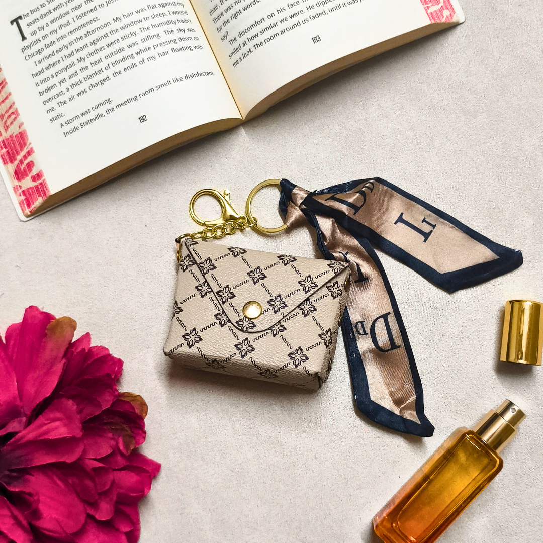 Small pouch with gold clasp, ribbon, and book on light surface