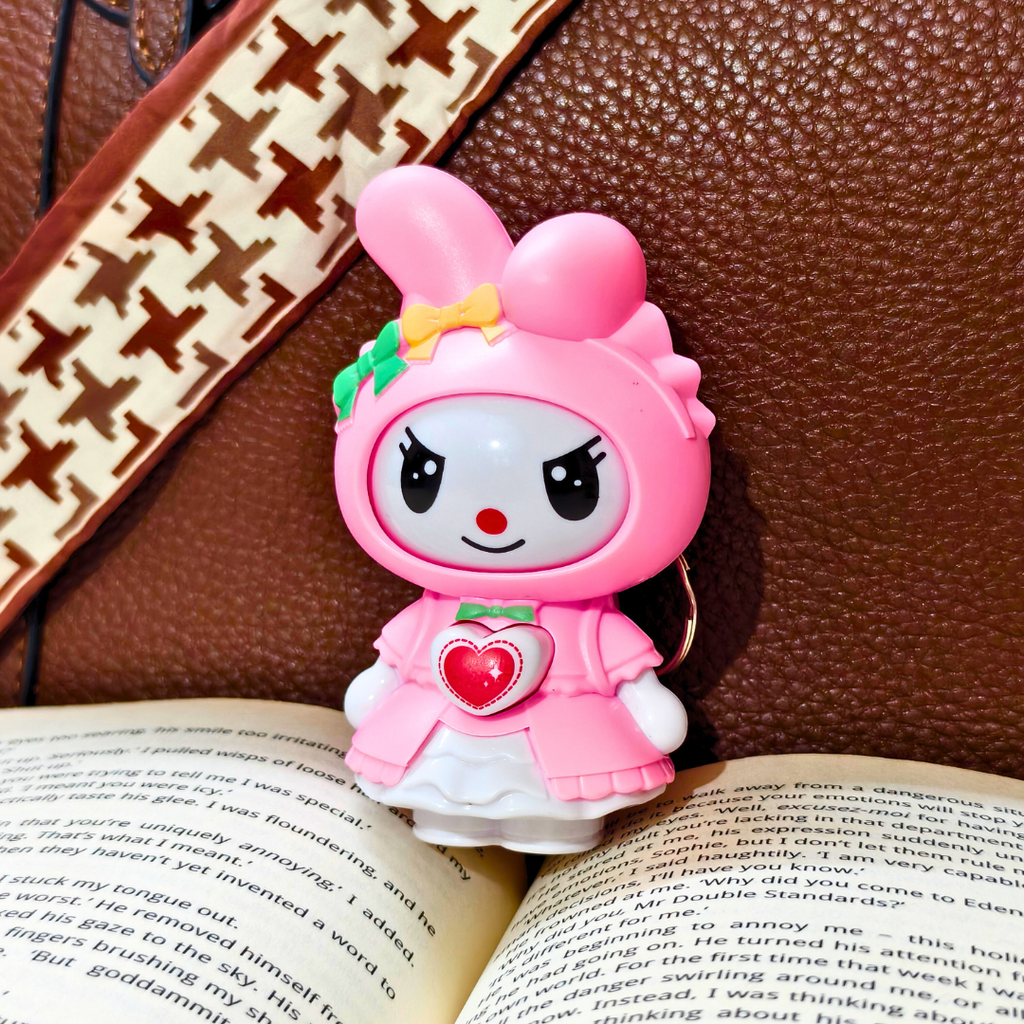 Pink cartoon character figurine on an open book with a brown textured background
