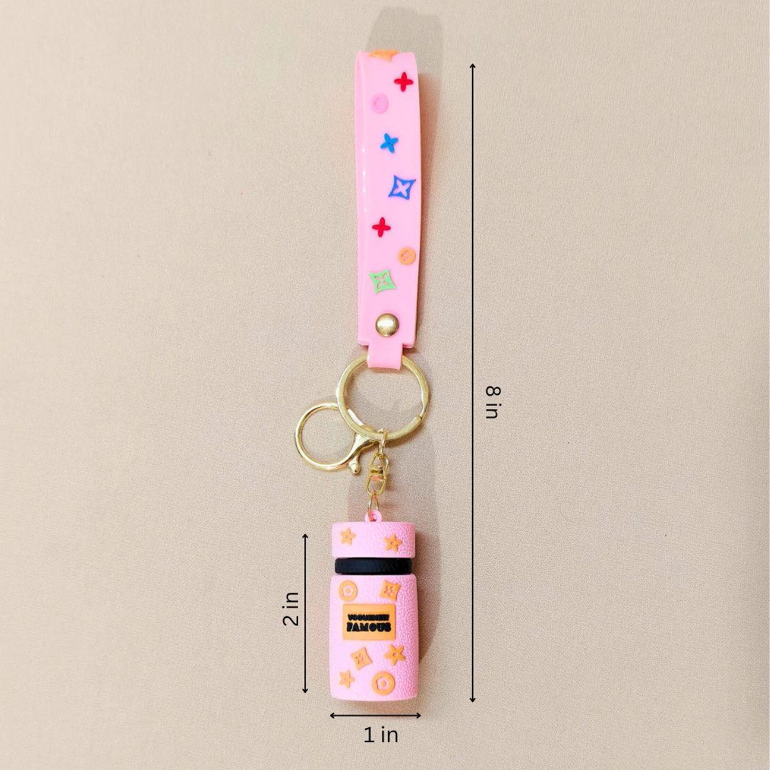 Pink keychain with colorful accents and dimensions on a beige background