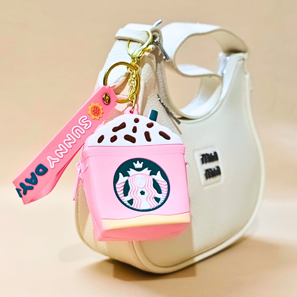 Pink Starbucks keychain with a cartoon character on a beige background