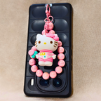Phone case with a Hello Kitty charm on a beige background