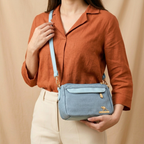 Person holding a blue handbag with a beige background